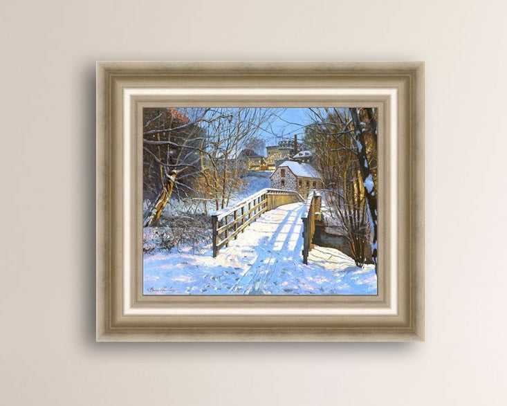 A framed canvas print featuring a Monocacy Bridge with snow on the ground, surrounded by trees and a historic Bethlehem building in the background.