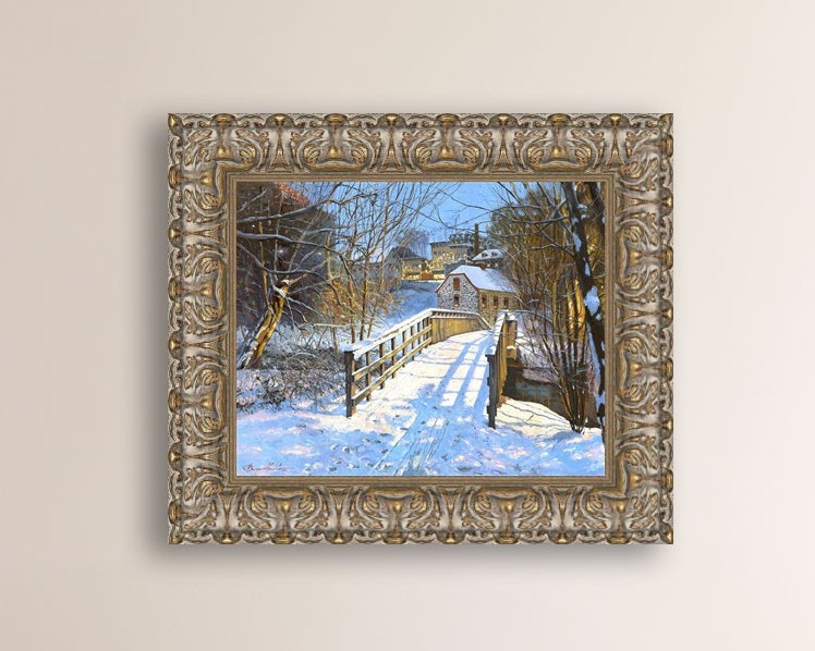 A framed canvas print featuring a Monocacy Bridge with snow on the ground, surrounded by trees and a historic Bethlehem building in the background.