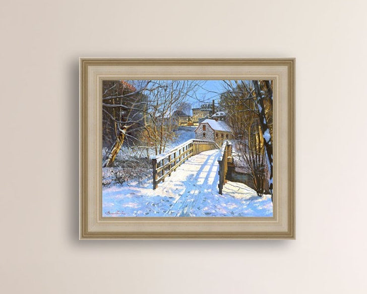 A framed canvas print featuring a Monocacy Bridge with snow on the ground, surrounded by trees and a historic Bethlehem building in the background.