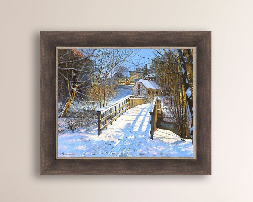 A framed canvas print featuring a Monocacy Bridge with snow on the ground, surrounded by trees and a historic Bethlehem building in the background.