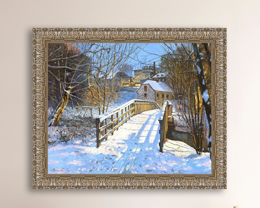 A framed canvas print featuring a Monocacy Bridge with snow on the ground, surrounded by trees and a historic Bethlehem building in the background.