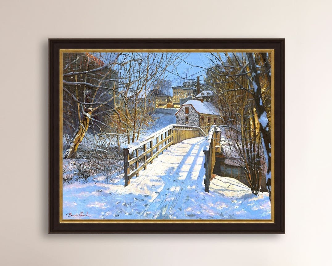 A framed canvas print featuring a Monocacy Bridge with snow on the ground, surrounded by trees and a historic Bethlehem building in the background.