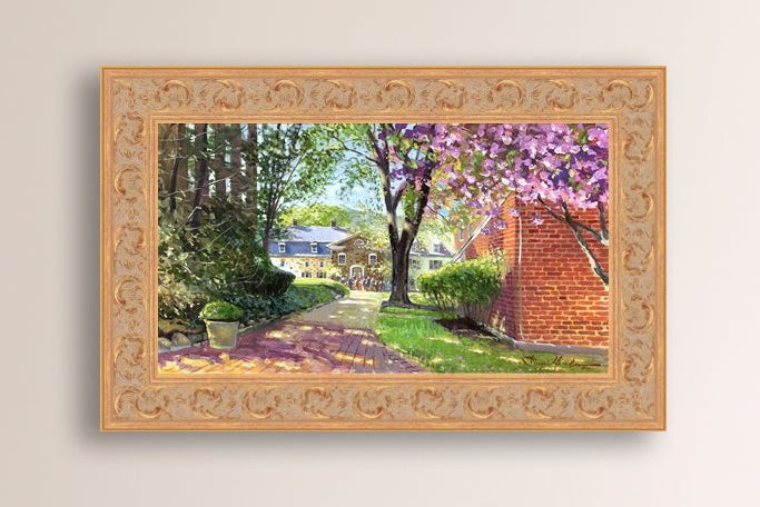 A canvas print depicting a vibrant spring scene with a pathway, trees in bloom, and a historic Moravian Chapel in the background.