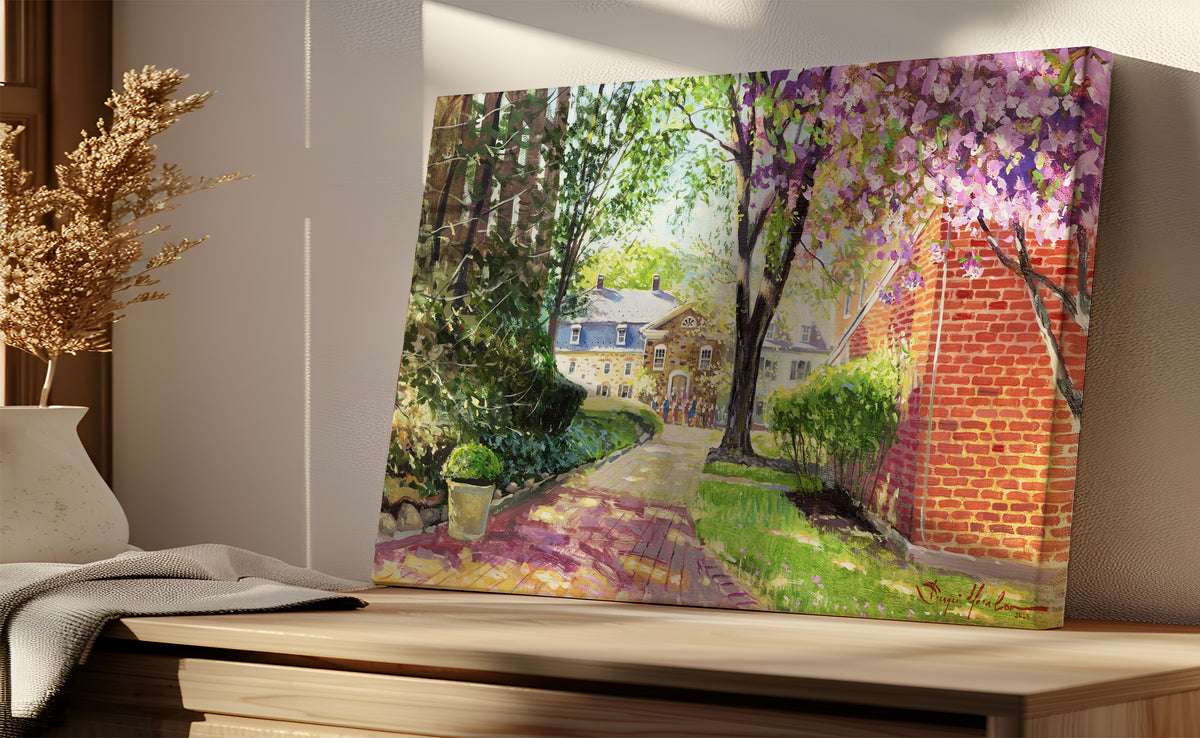 A canvas print depicting a vibrant spring scene with a pathway, trees in bloom, and a historic Moravian Chapel in the background.