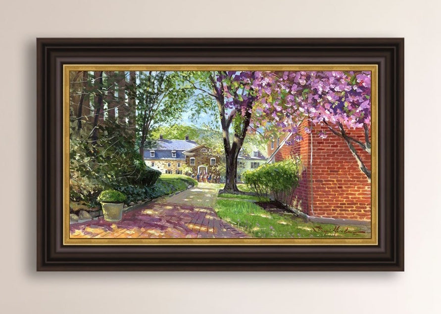 A canvas print depicting a vibrant spring scene with a pathway, trees in bloom, and a historic Moravian Chapel in the background.