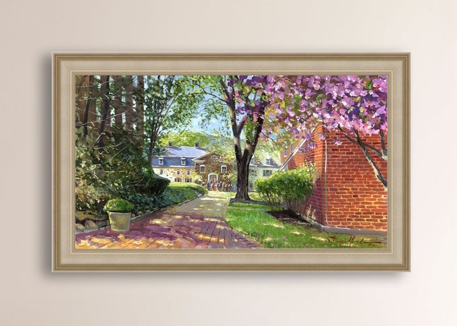 A canvas print depicting a vibrant spring scene with a pathway, trees in bloom, and a historic Moravian Chapel in the background.