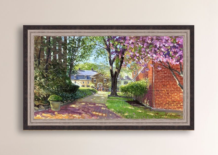 A canvas print depicting a vibrant spring scene with a pathway, trees in bloom, and a historic Moravian Chapel in the background.