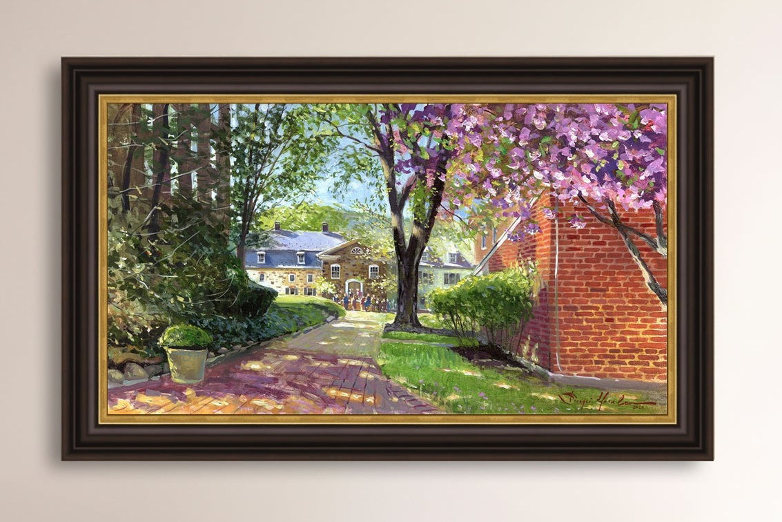 A canvas print depicting a vibrant spring scene with a pathway, trees in bloom, and a historic Moravian Chapel in the background.