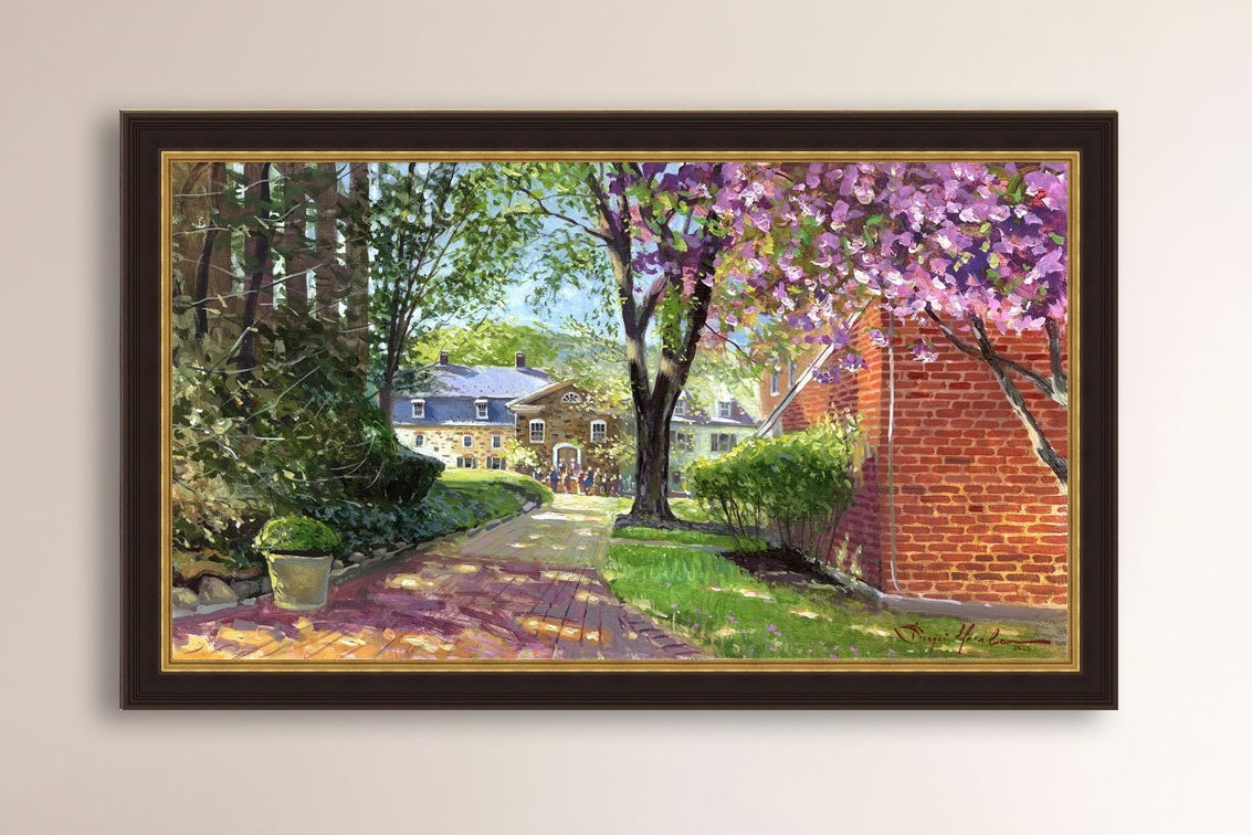 A canvas print depicting a vibrant spring scene with a pathway, trees in bloom, and a historic Moravian Chapel in the background.
