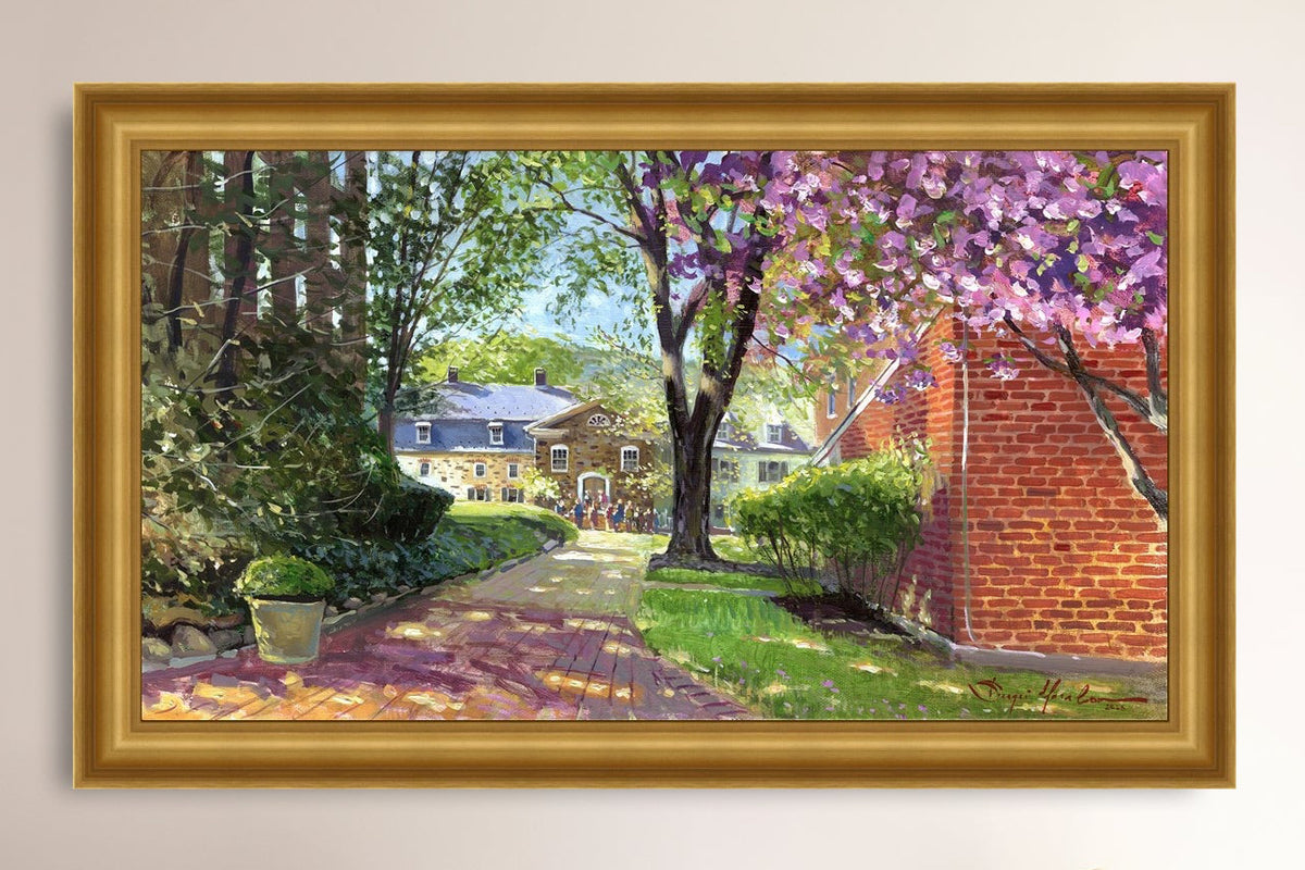 A canvas print depicting a vibrant spring scene with a pathway, trees in bloom, and a historic Moravian Chapel in the background.
