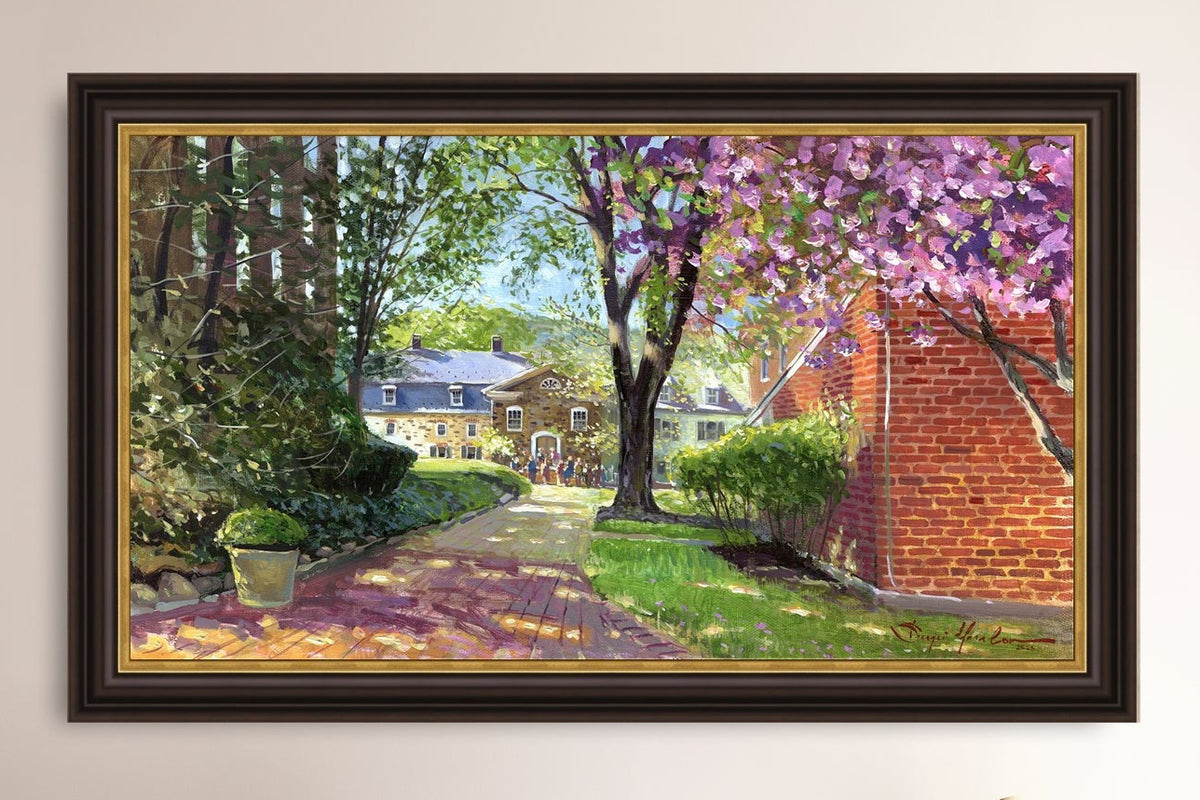 A canvas print depicting a vibrant spring scene with a pathway, trees in bloom, and a historic Moravian Chapel in the background.