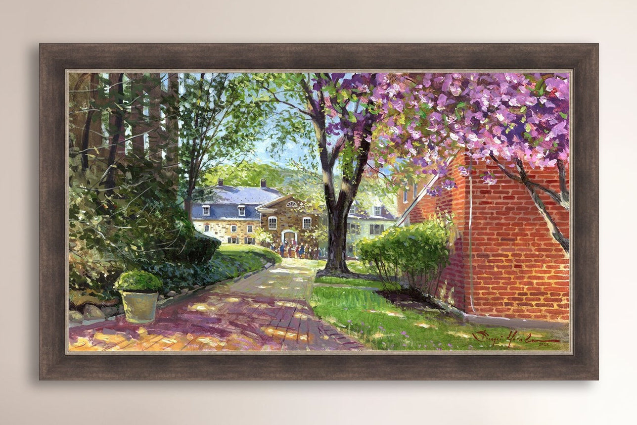A canvas print depicting a vibrant spring scene with a pathway, trees in bloom, and a historic Moravian Chapel in the background.