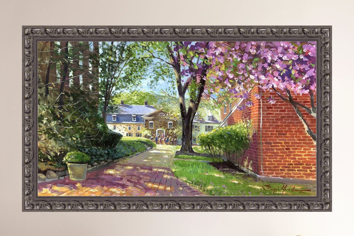 A canvas print depicting a vibrant spring scene with a pathway, trees in bloom, and a historic Moravian Chapel in the background.