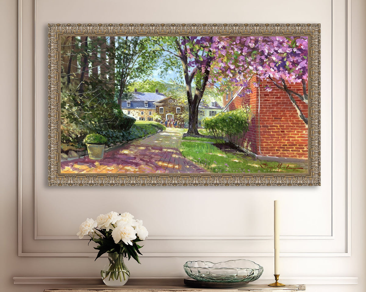 A canvas print depicting a vibrant spring scene with a pathway, trees in bloom, and a historic Moravian Chapel in the background.
