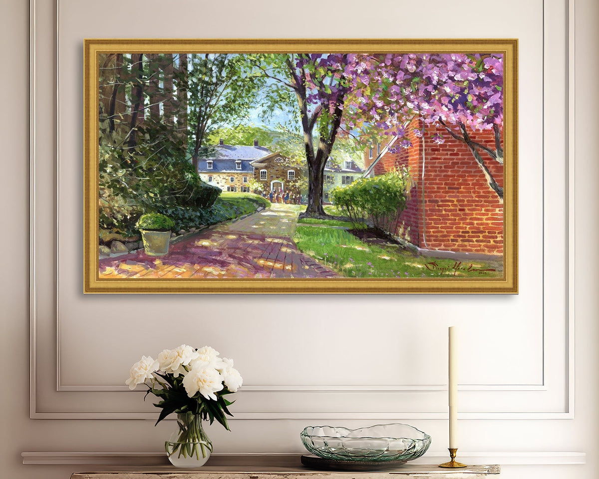 A canvas print depicting a vibrant spring scene with a pathway, trees in bloom, and a historic Moravian Chapel in the background.