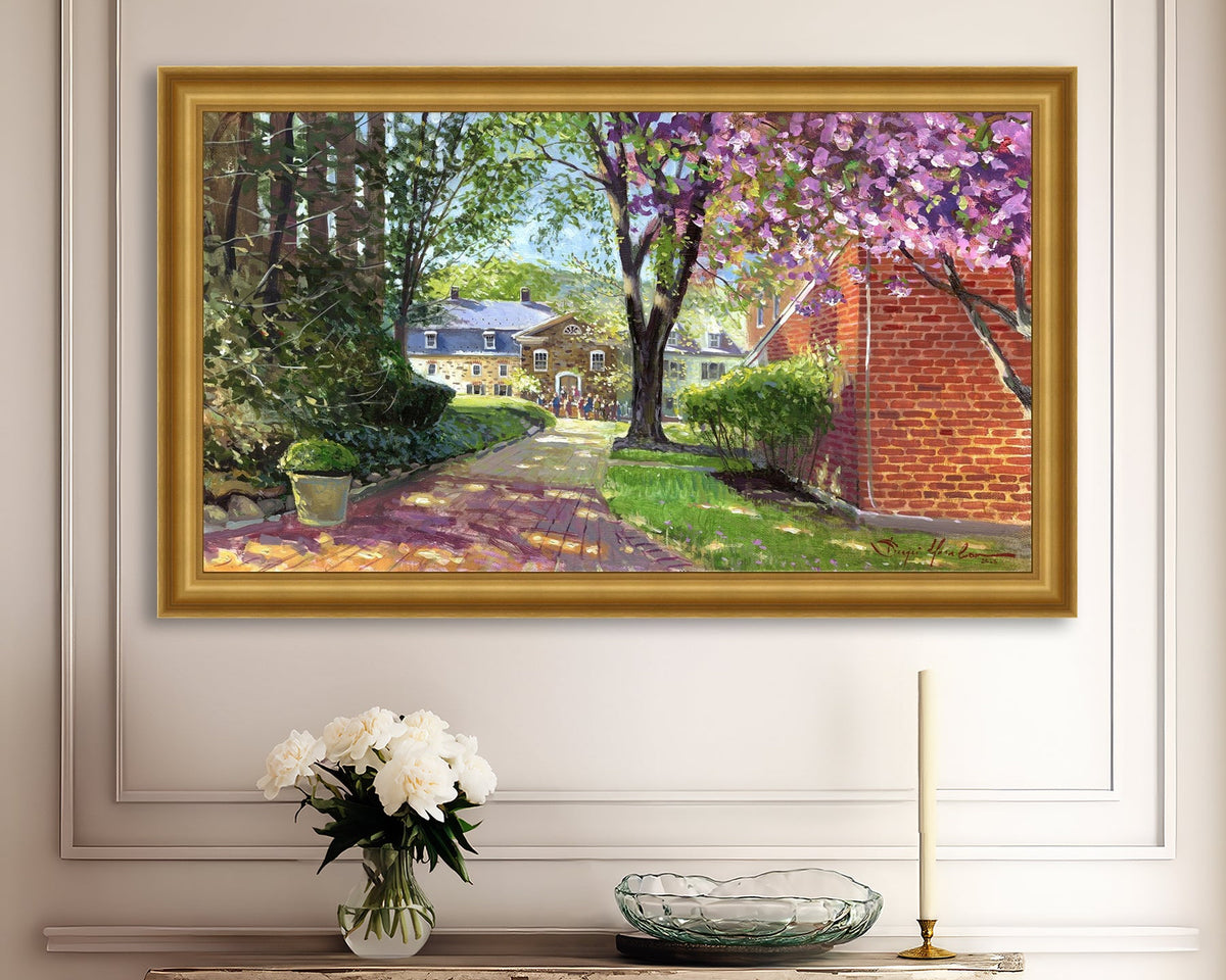 A canvas print depicting a vibrant spring scene with a pathway, trees in bloom, and a historic Moravian Chapel in the background.
