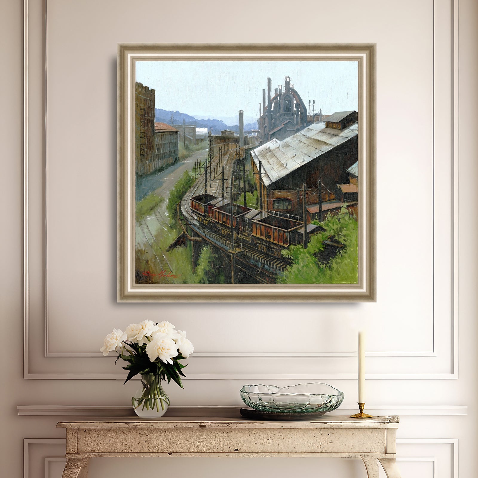 Framed painting of an industrial Bethlehem Steel scene on a wall above a console table with decorative items.