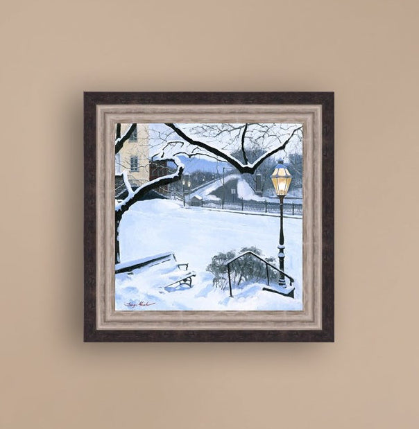 A canvas print featuring a snowy landscape with a bench, a lamp post, in the foreground, and Moravian Church in the background.