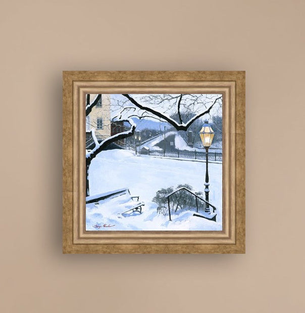 A canvas print featuring a snowy landscape with a bench, a lamp post, in the foreground, and Moravian Church in the background.