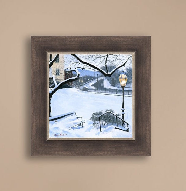A canvas print featuring a snowy landscape with a bench, a lamp post, in the foreground, and Moravian Church in the background.