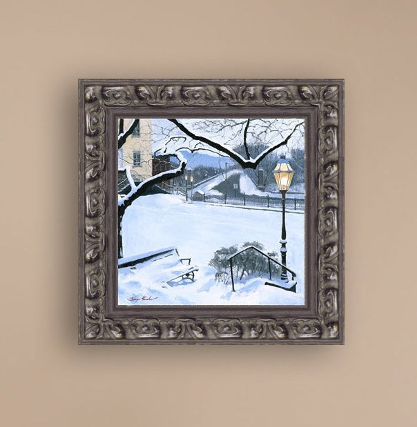 A canvas print featuring a snowy landscape with a bench, a lamp post, in the foreground, and Moravian Church in the background.