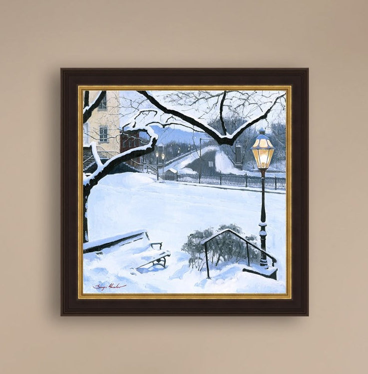 A canvas print featuring a snowy landscape with a bench, a lamp post, in the foreground, and Moravian Church in the background.