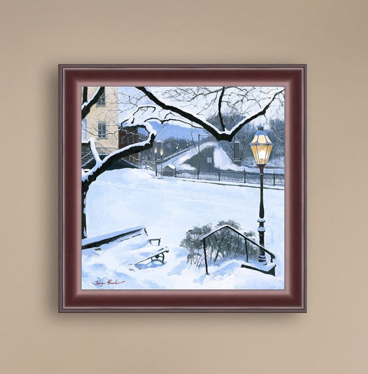 A canvas print featuring a snowy landscape with a bench, a lamp post, in the foreground, and Moravian Church in the background.