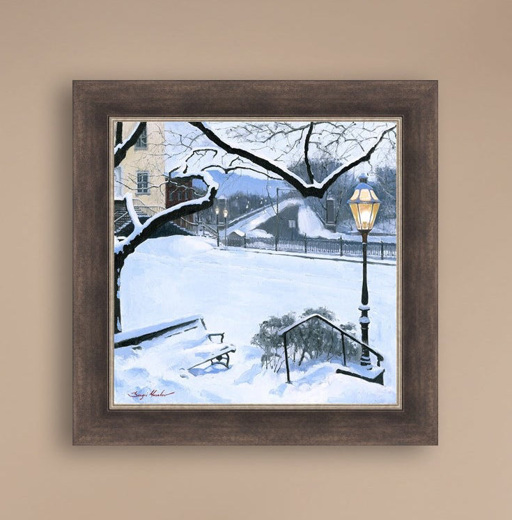 A canvas print featuring a snowy landscape with a bench, a lamp post, in the foreground, and Moravian Church in the background.
