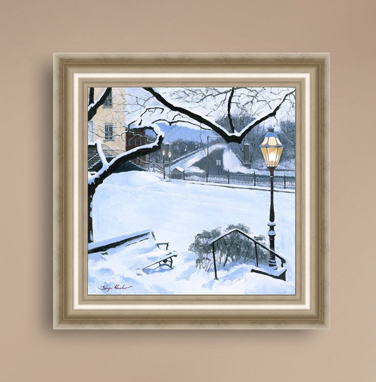 A canvas print featuring a snowy landscape with a bench, a lamp post, in the foreground, and Moravian Church in the background.