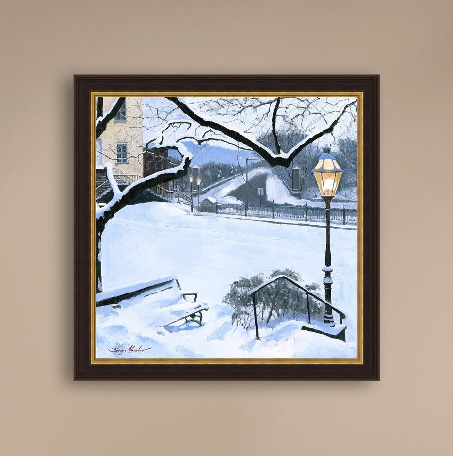 A canvas print featuring a snowy landscape with a bench, a lamp post, in the foreground, and Moravian Church in the background.