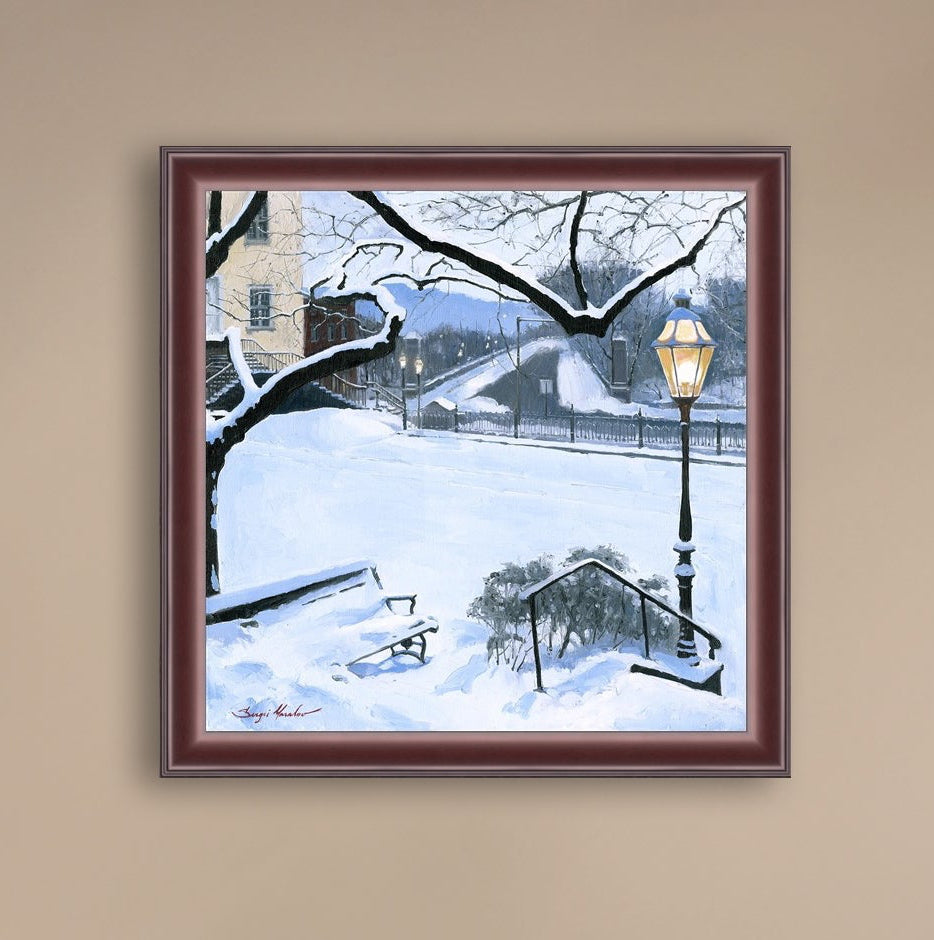 A canvas print featuring a snowy landscape with a bench, a lamp post, in the foreground, and Moravian Church in the background.
