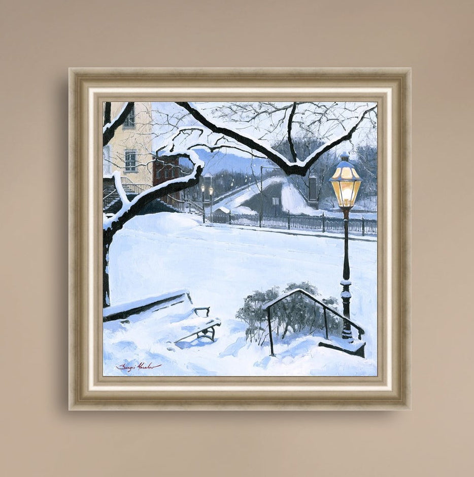 A canvas print featuring a snowy landscape with a bench, a lamp post, in the foreground, and Moravian Church in the background.