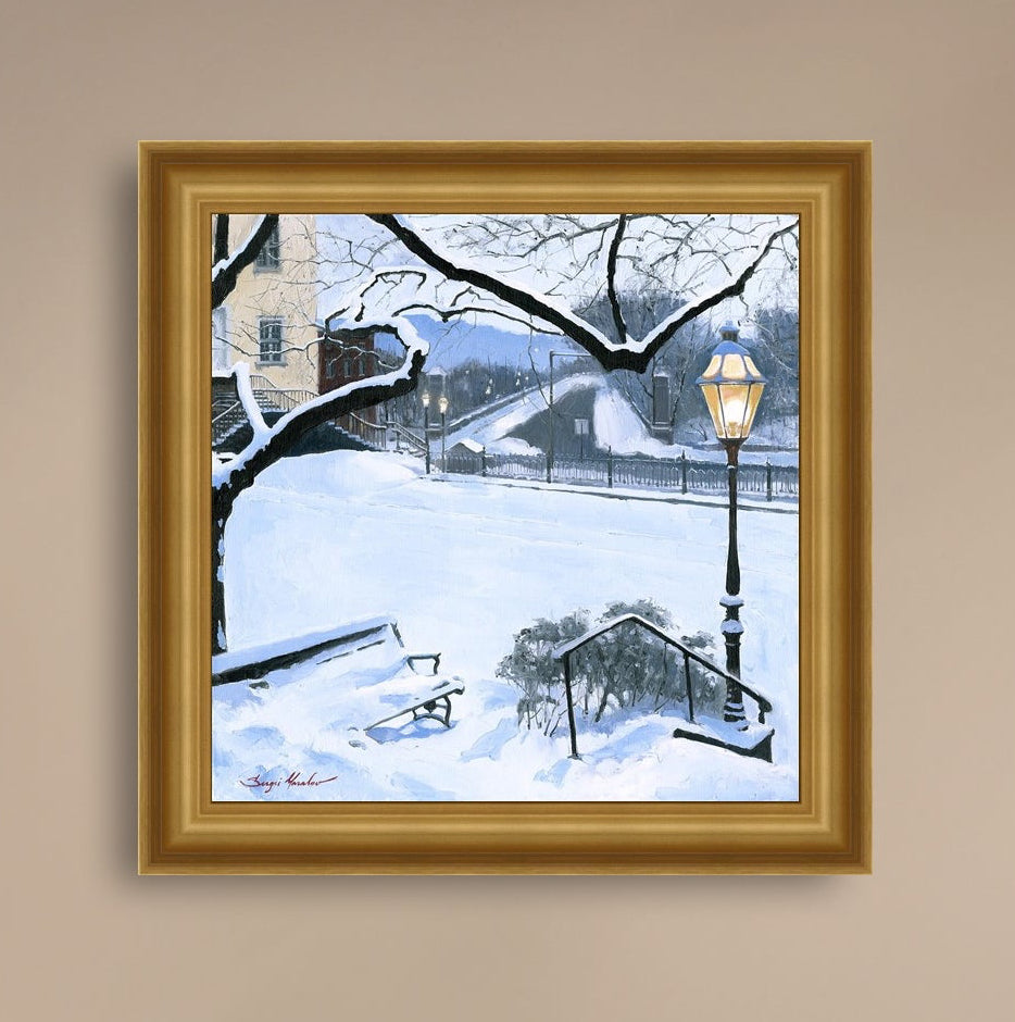 A canvas print featuring a snowy landscape with a bench, a lamp post, in the foreground, and Moravian Church in the background.