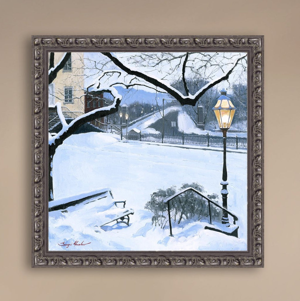 A canvas print featuring a snowy landscape with a bench, a lamp post, in the foreground, and Moravian Church in the background.