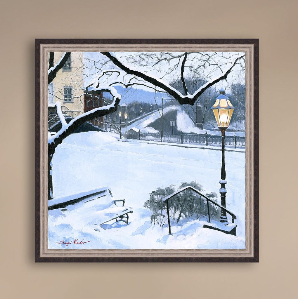 A canvas print featuring a snowy landscape with a bench, a lamp post, in the foreground, and Moravian Church in the background.