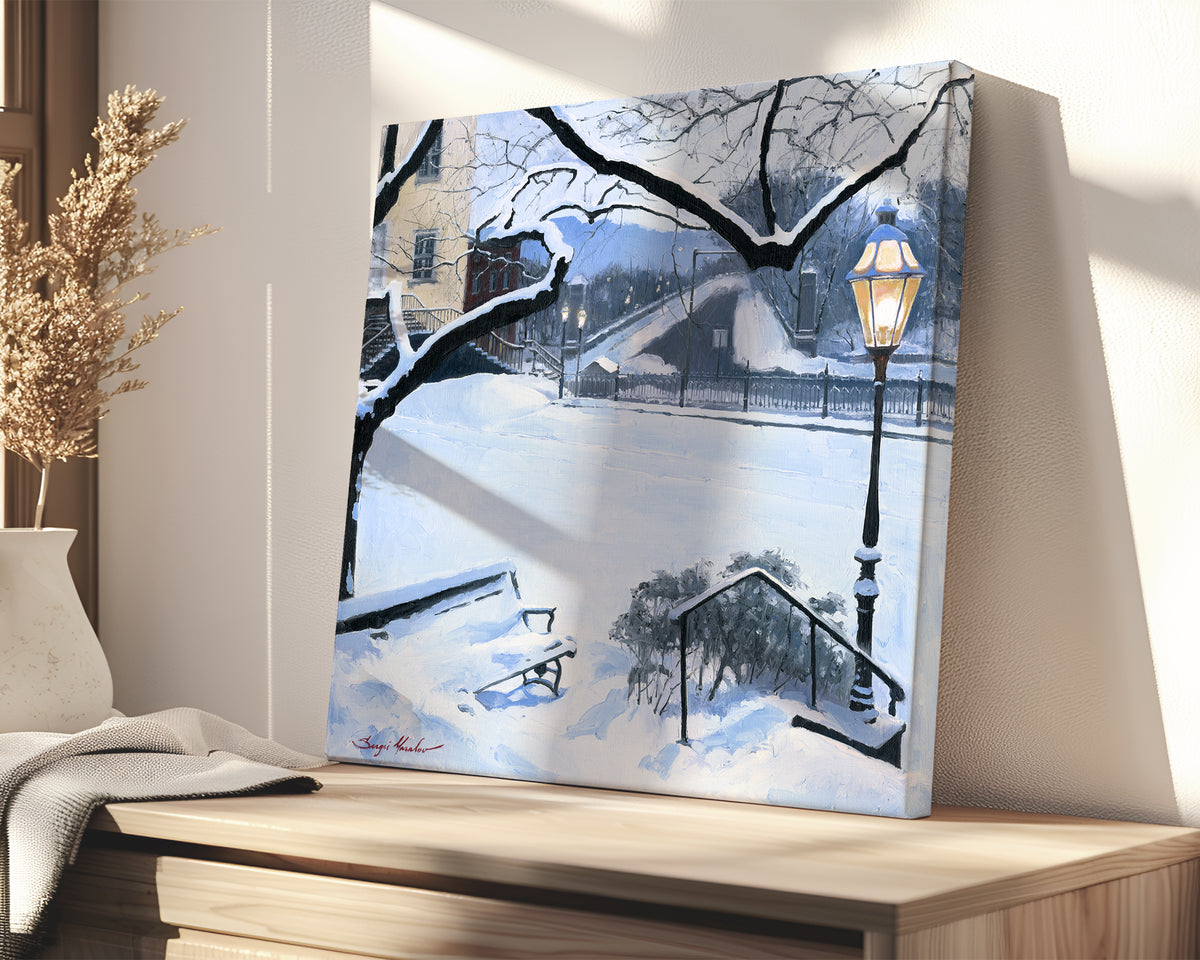 A canvas print featuring a snowy landscape with a bench, a lamp post, in the foreground, and Moravian Church in the background.